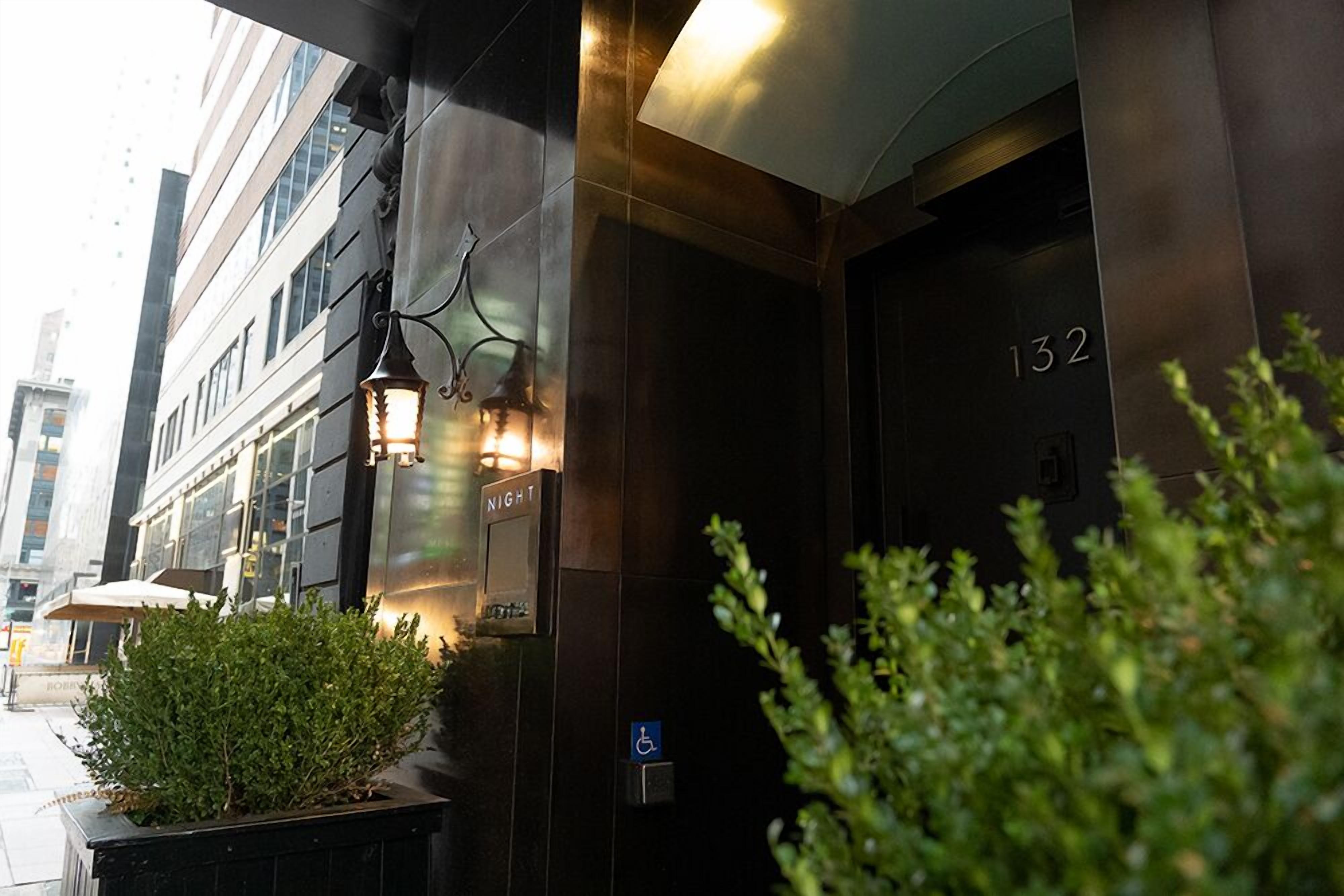 A hotel entrance with a sign indicating room number 132, a night indicator, and a disabled parking symbol.