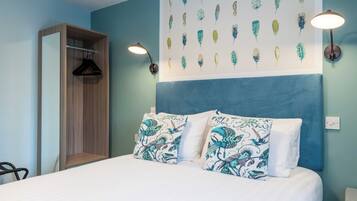 Un dormitorio con cama, armario colgante, una pared decorada con arte de plumas y una lámpara de pared.