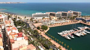 A coastal cityscape with a marina, a hotel named "Meliá Alicante," and a beach area. - Melia Alicante (Alicante)