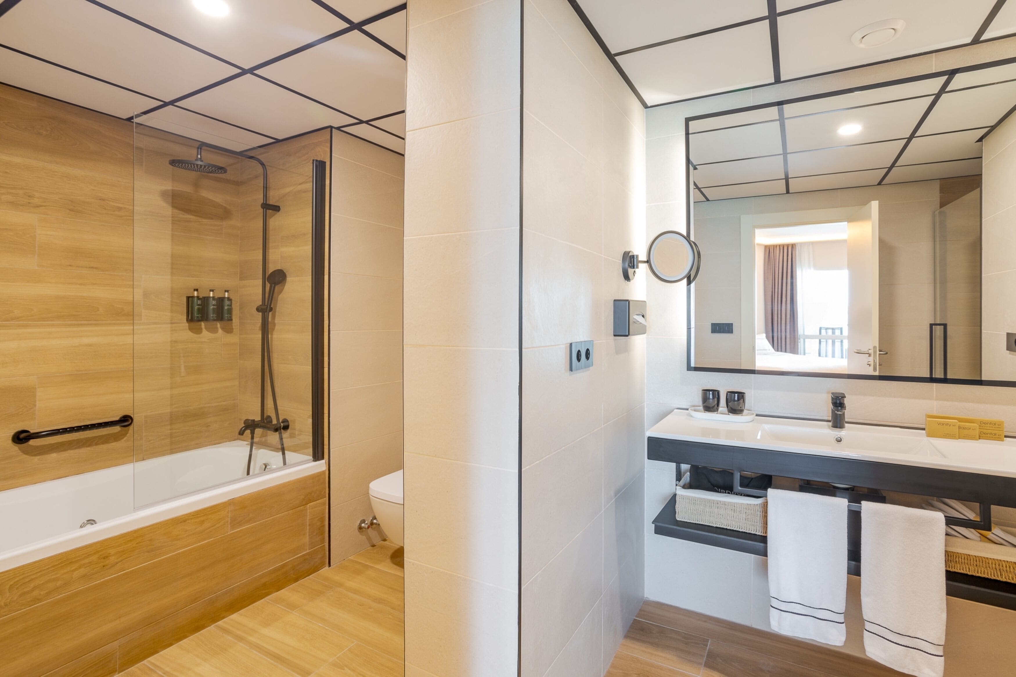 Une salle de bain moderne dotée d’une douche à parois de verre, d’une baignoire sur pieds et d’un meuble-lavabo avec un miroir.