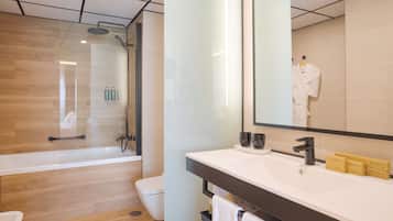 A modern bathroom with a glass-enclosed shower, a white sink with vanity items, and a large mirror.