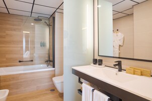 A modern bathroom with a glass-enclosed shower, a white sink with vanity items, and a large mirror.