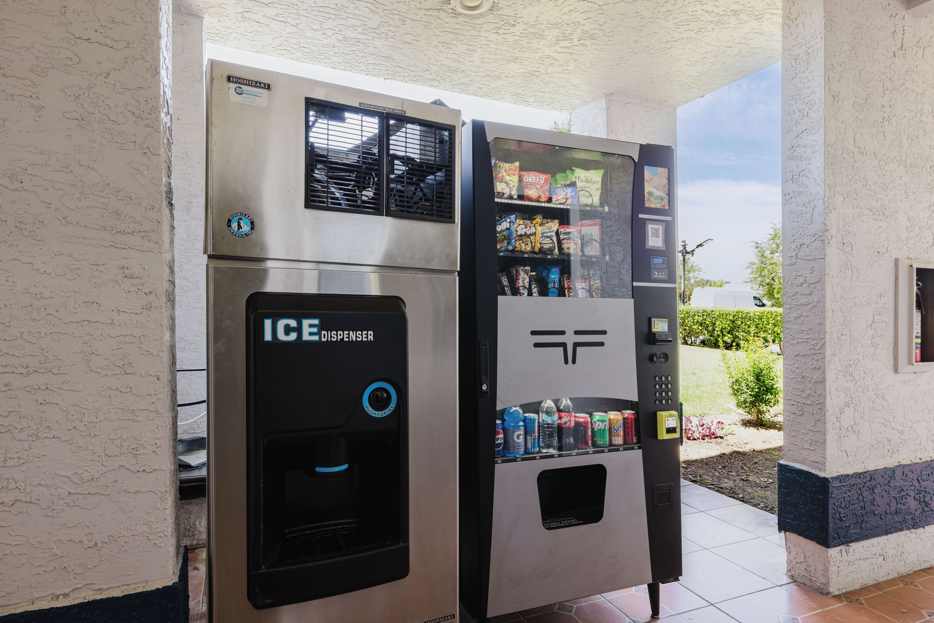 An ice dispenser and a vending machine with various beverages and snacks.