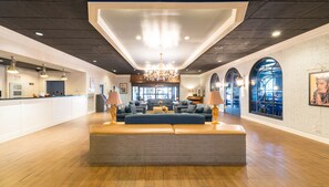 A spacious lobby with a central seating area, a reception desk, and a chandelier. - Travelodge by Wyndham Memphis Airport/Graceland (Memphis)