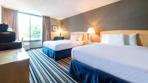 A hotel room with two beds, a desk, and a window with curtains. - Travelodge by Wyndham Memphis Airport/Graceland (Memphis)