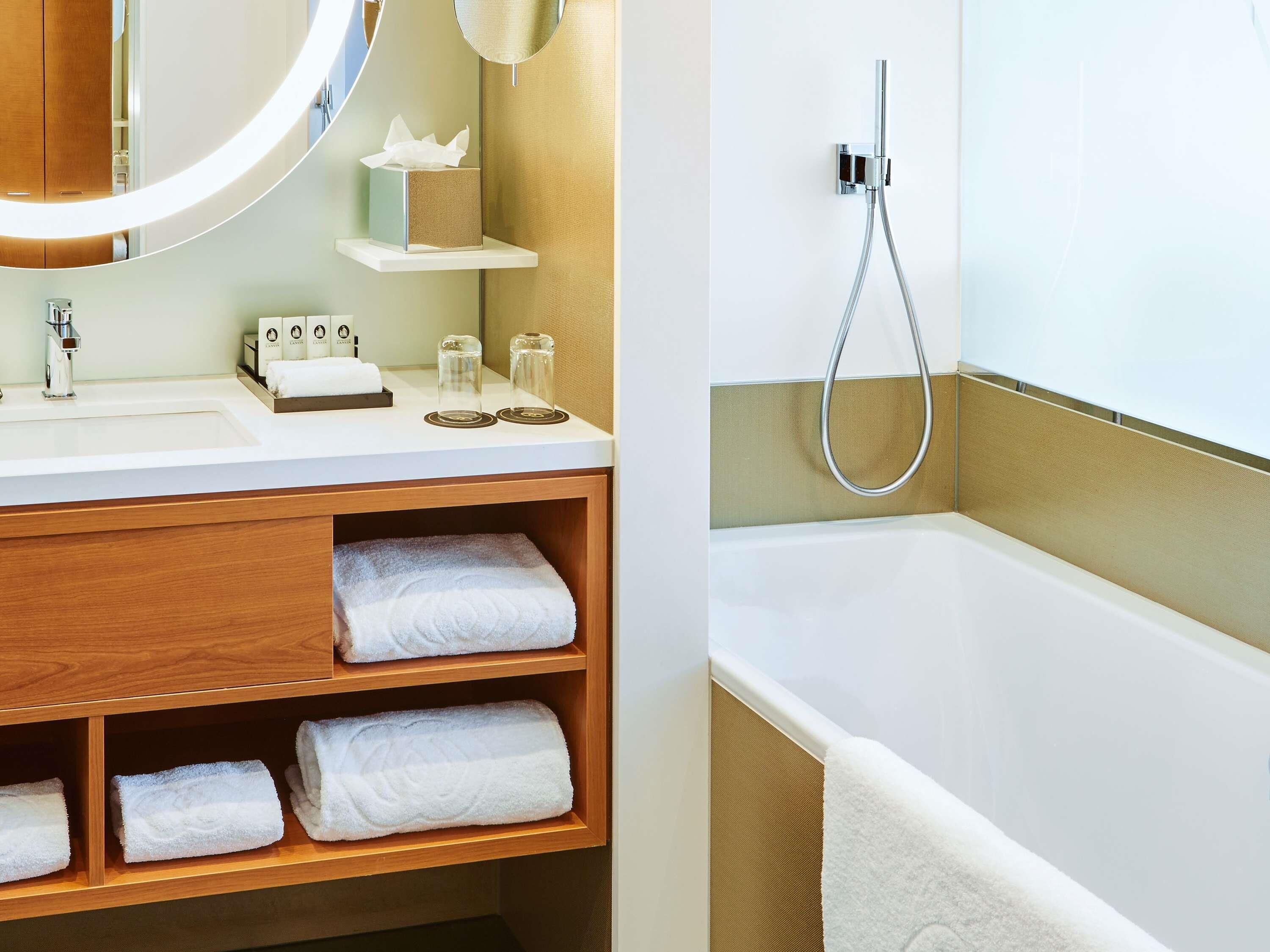 Une salle de bain équipée d’un lavabo, d’un miroir, d’un porte-serviettes et d’une douche.