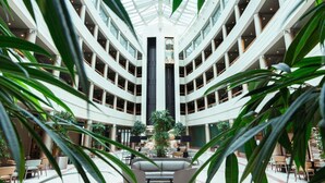 A multi-level atrium with a central column, surrounded by seating areas and plants.