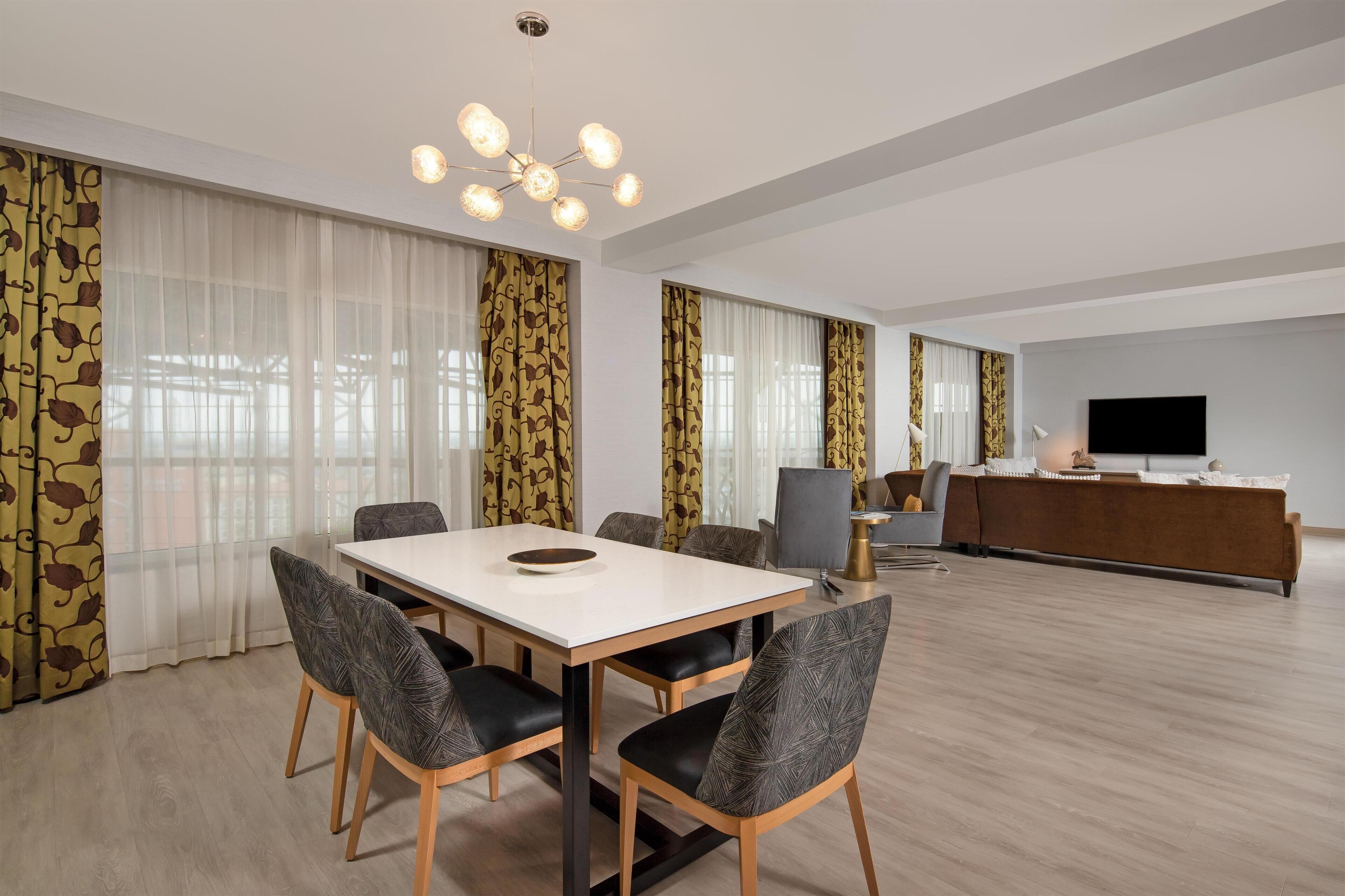A modern living room with a dining area, a TV, and a sofa.