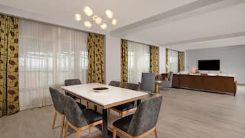 A modern living room with a dining area, a TV, and a sofa.