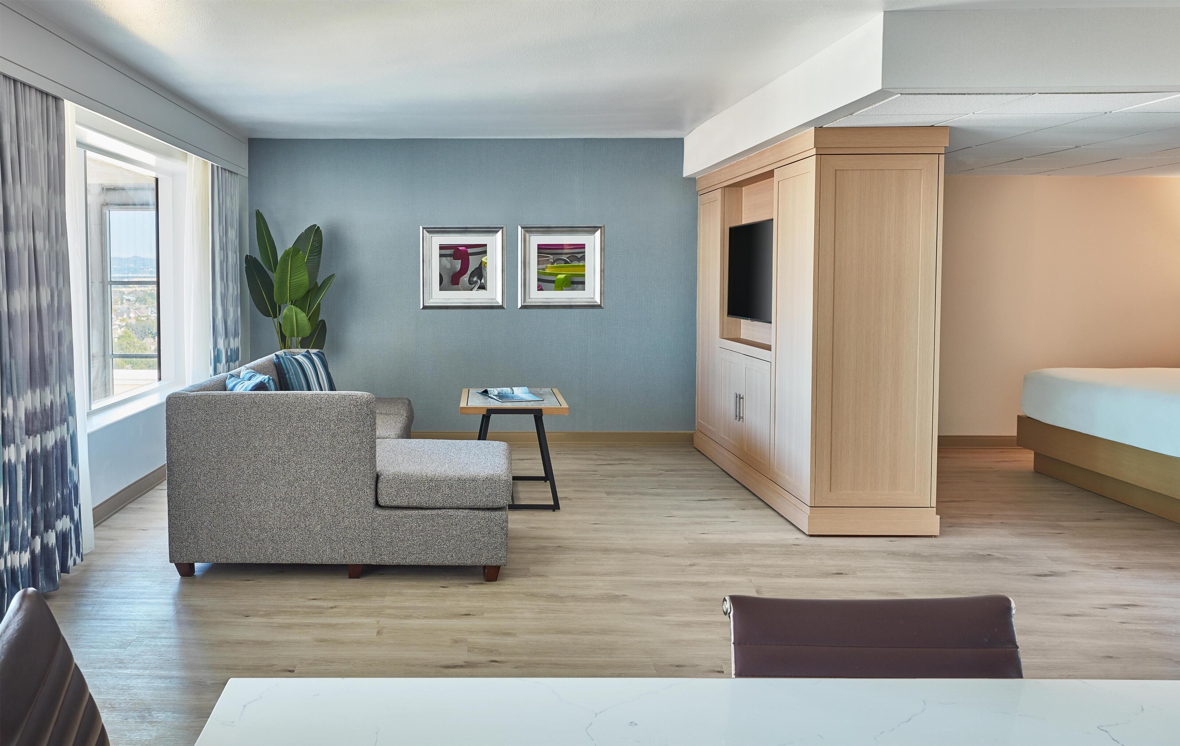 Una sala moderna con un sofá, una mesita, un televisor y un mueble aparador.