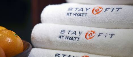 A stack of towels with "STAY @ FIT" embroidered on them.