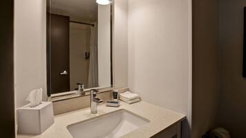 Un baño moderno con un espejo grande, un lavabo y un perchero para toallas.