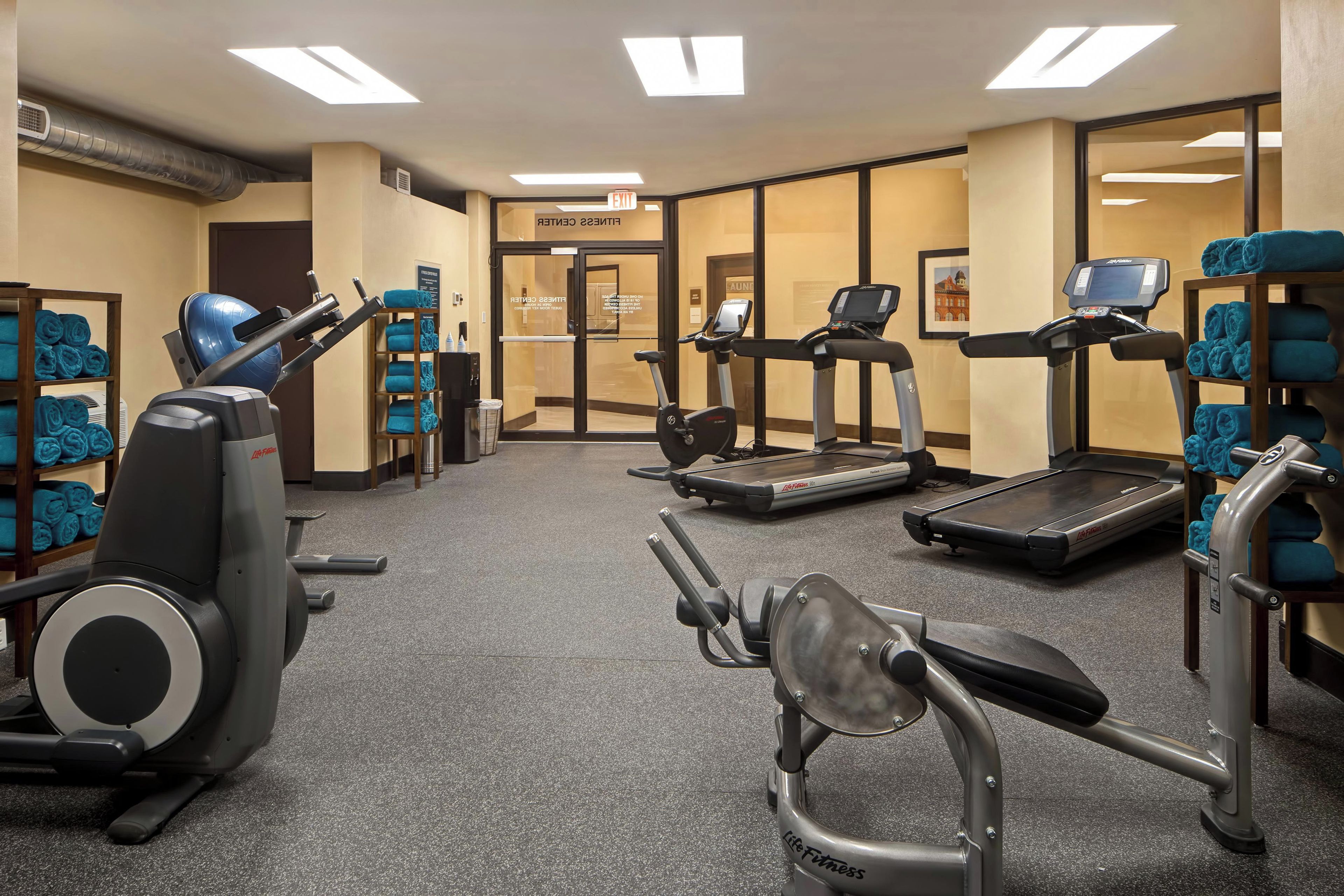 Un centre de remise en forme équipé de machines de cardio, d’un tapis de course et d’un rameur.