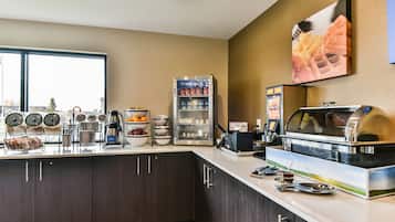 Un angolo colazione con frigorifero, macchina del caffè e buffet.