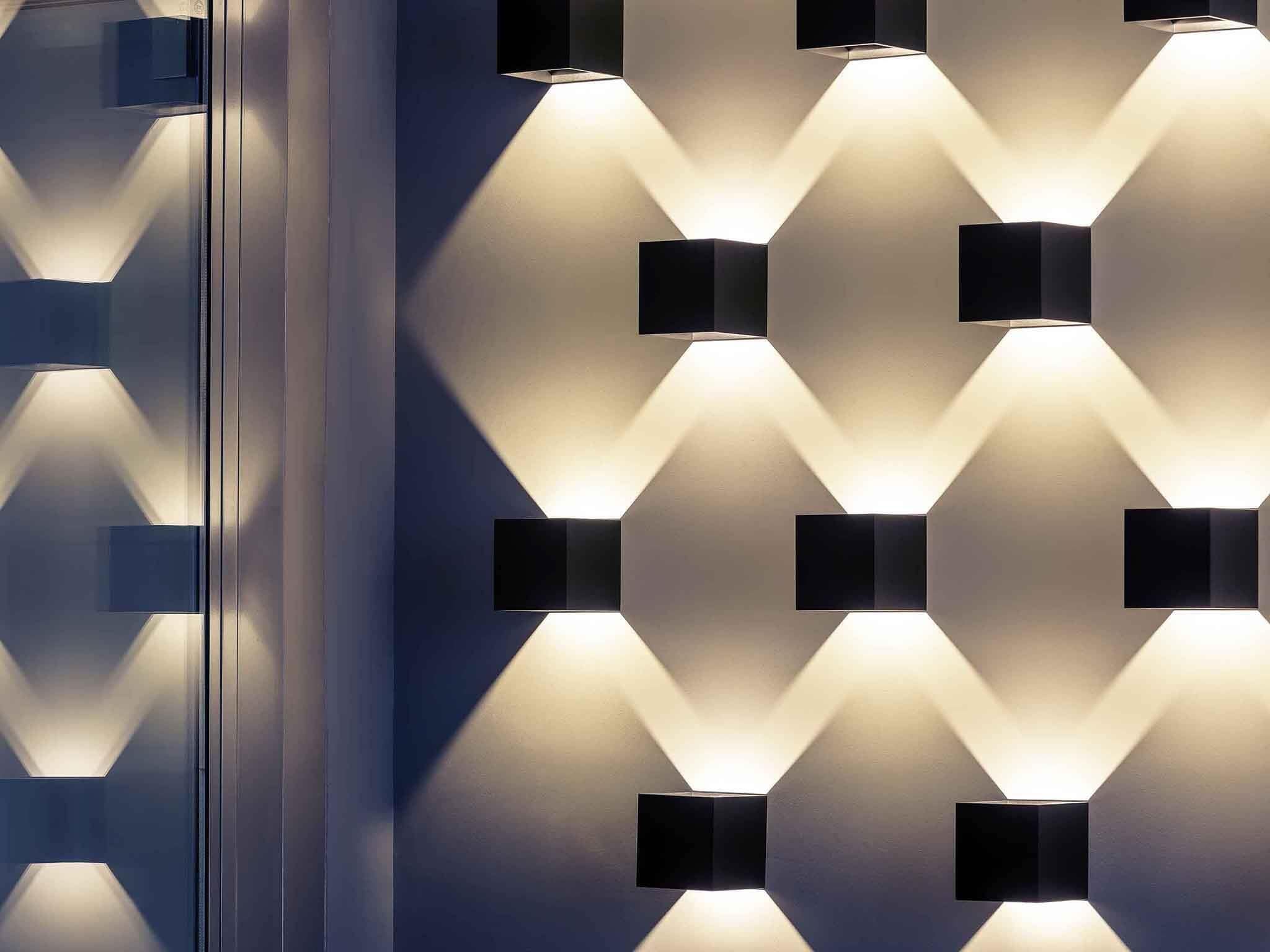 Una parete moderna con lampade geometriche.