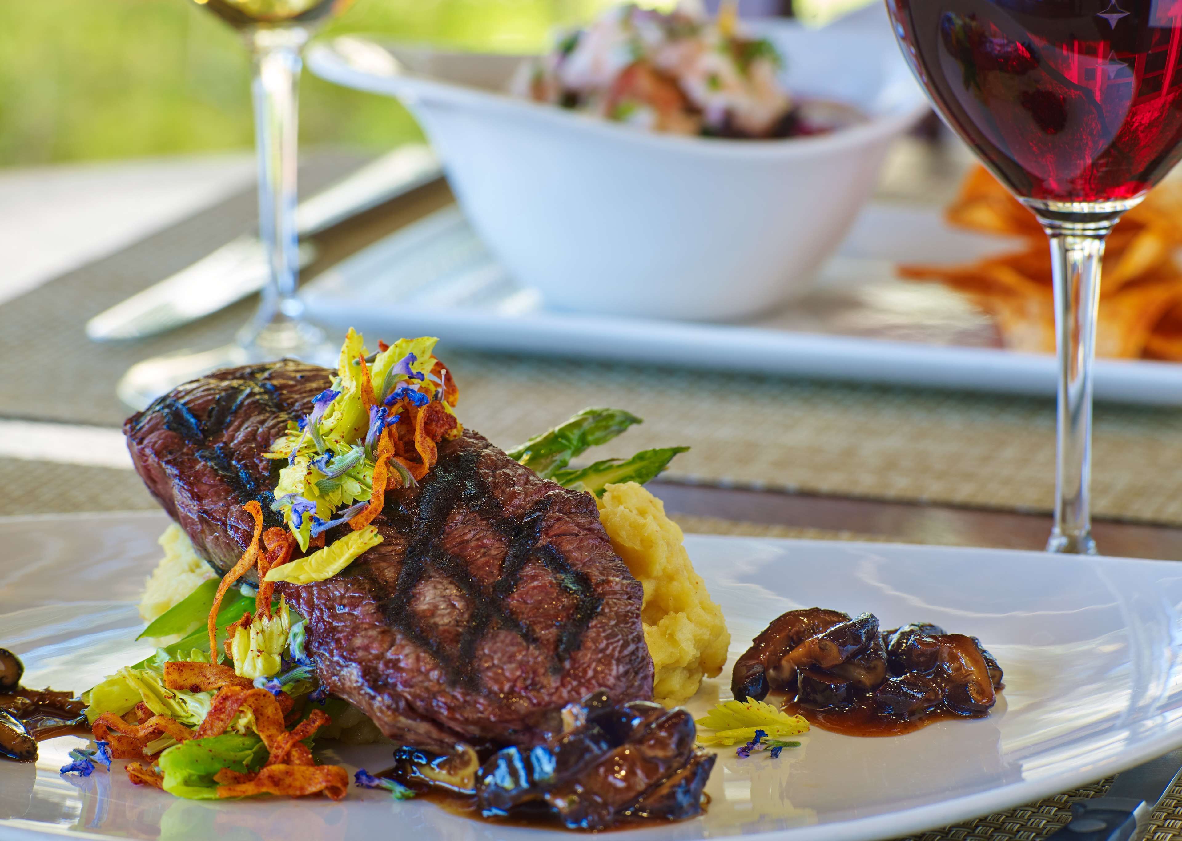 A plate of food with a steak, mashed potatoes, and mushrooms.