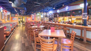 Un restaurante con cabinas, mesas y una zona de bar.
