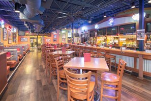 A restaurant with booths, tables, and a bar area. - Wyndham Grand Executive Center Little Rock Airport (Little Rock)