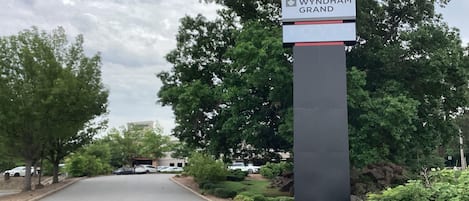Una carretera que conduce a un edificio con un cartel que dice 'Wyndham Grand'.