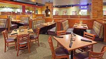 A restaurant with booths and tables, some with remote controls on them.