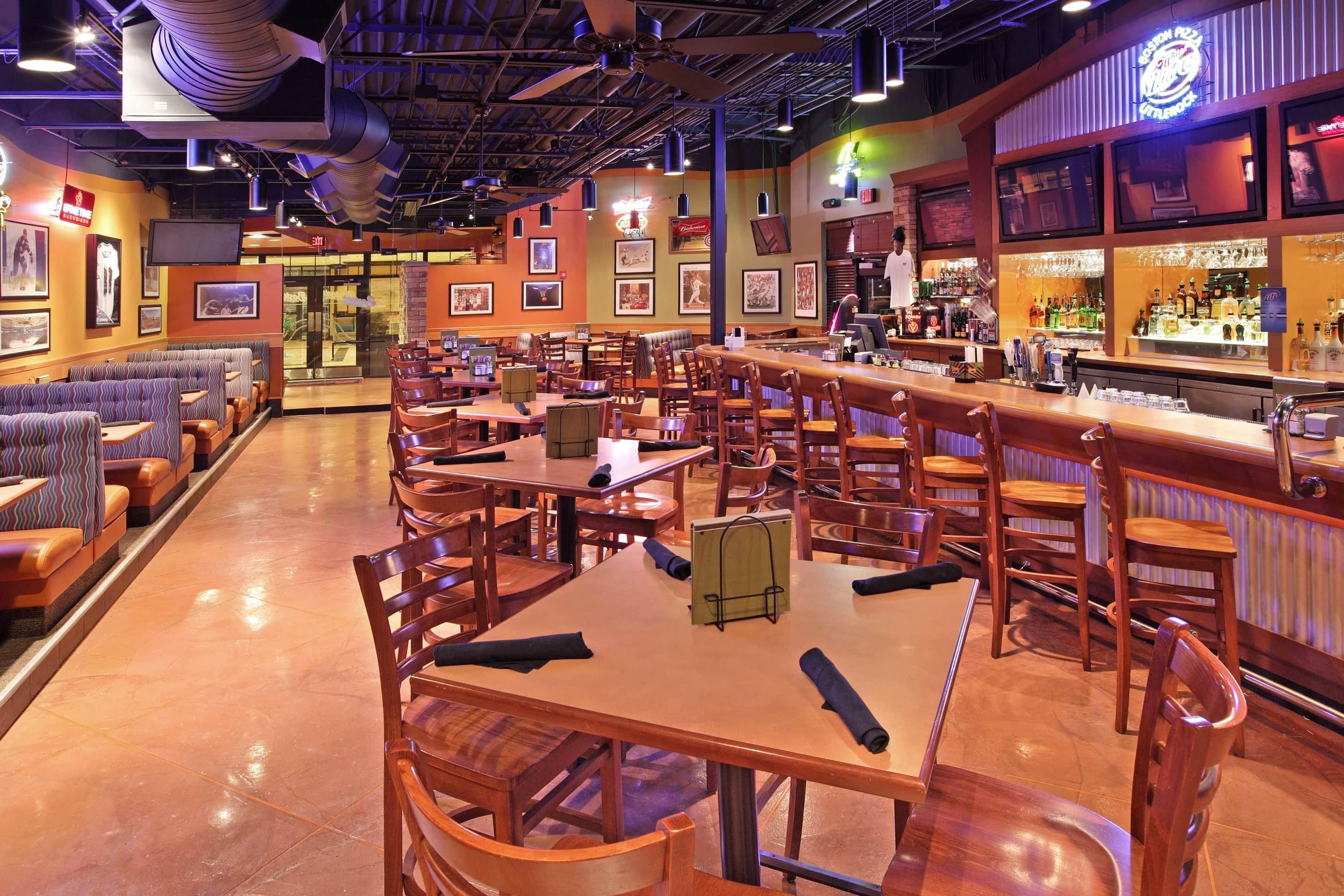 A restaurant with booths, tables, and a bar area.
