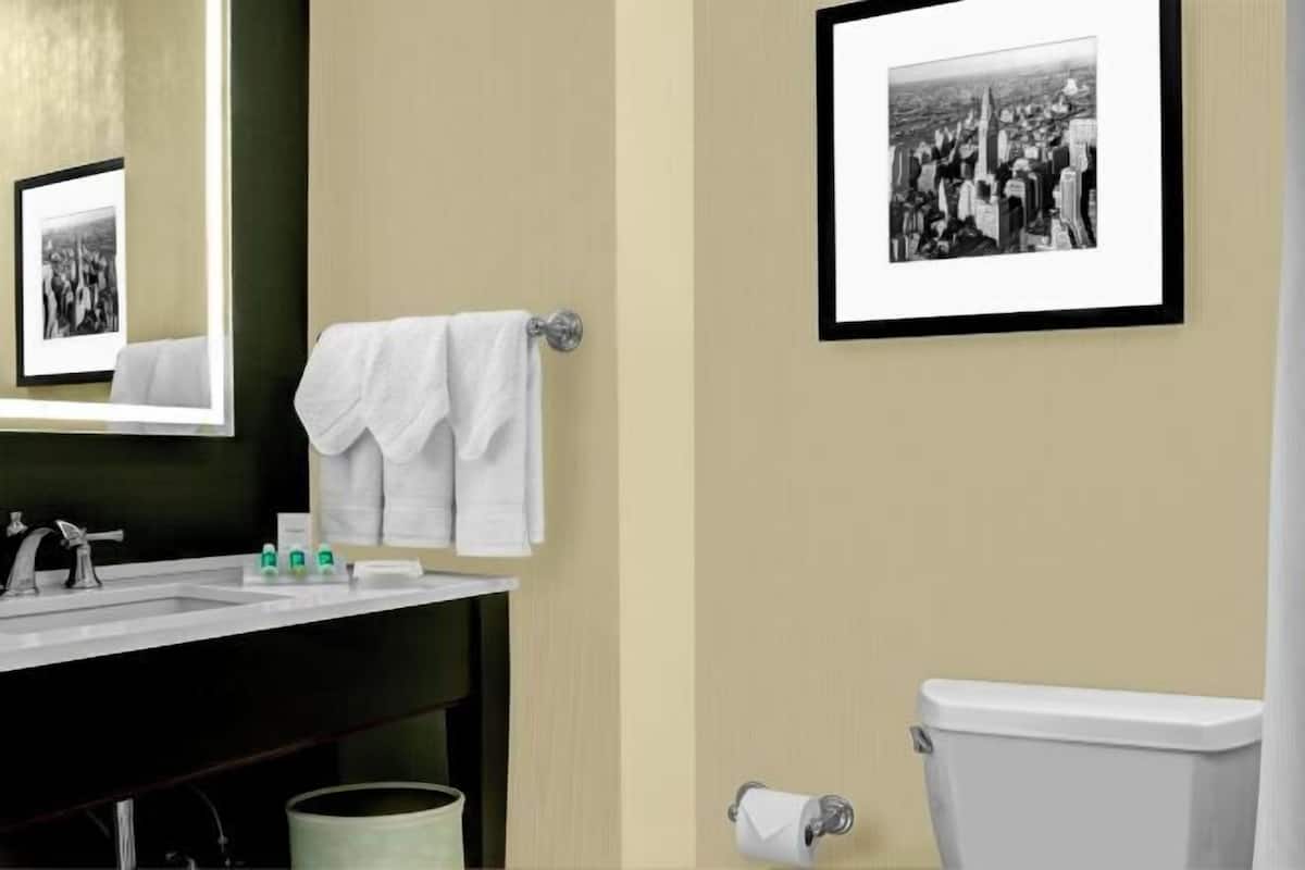 Badkamer | Een bad/douchecombinatie, designer toiletartikelen, een haardroger