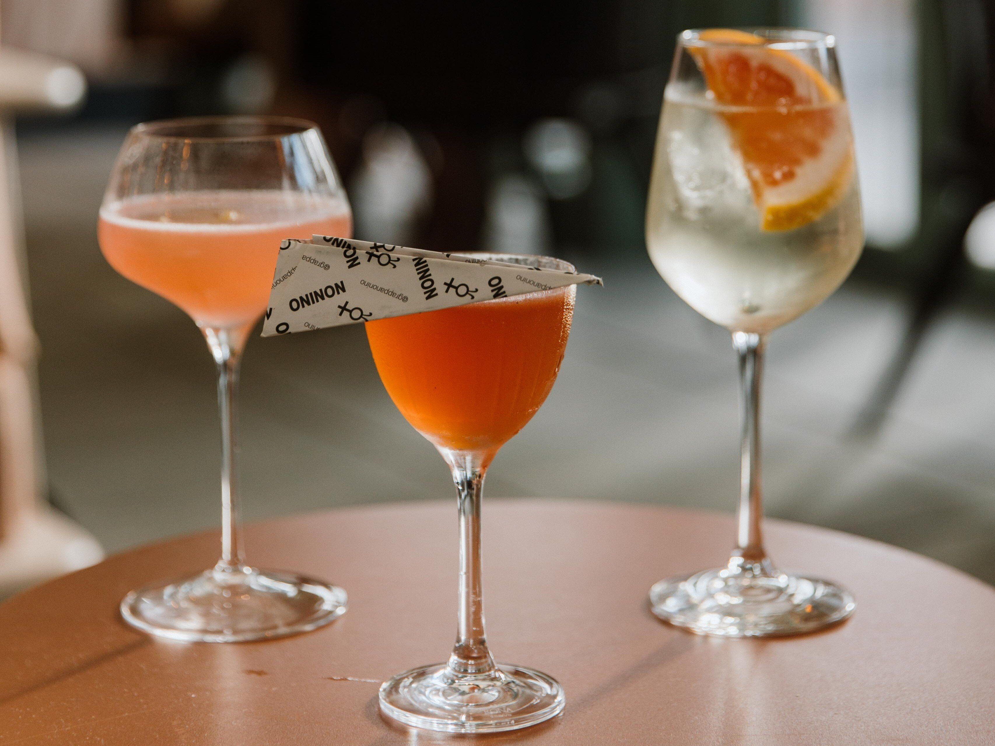 Tres vasos de diferentes bebidas sobre una mesa redonda.