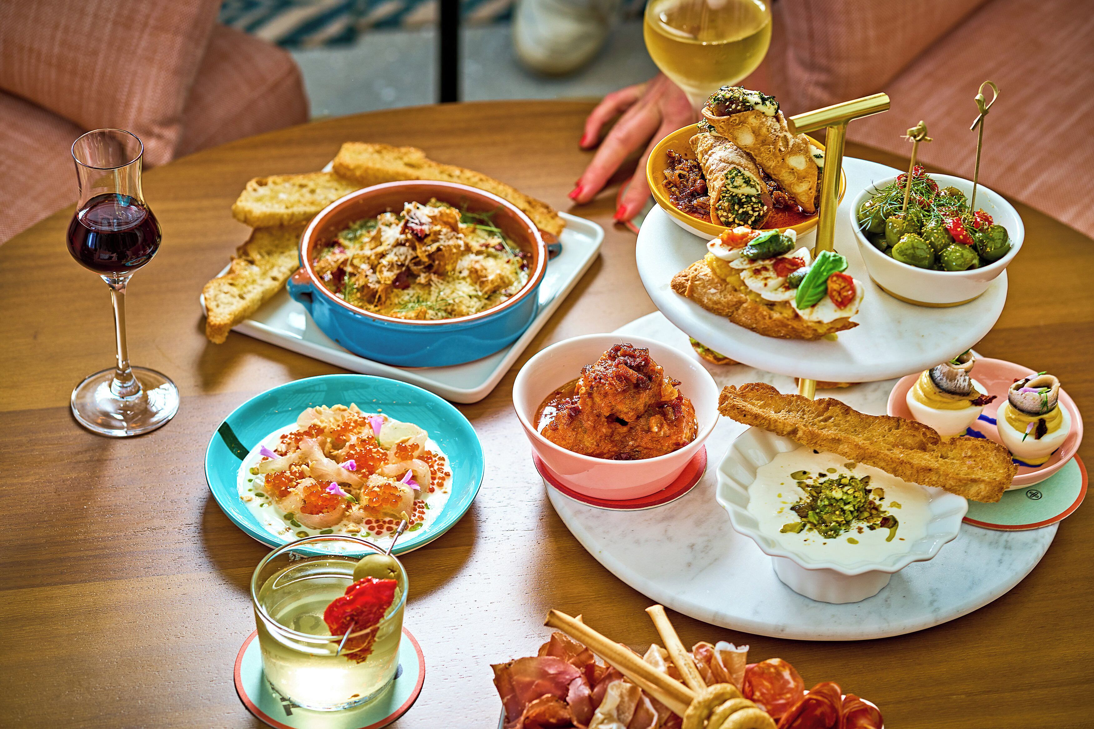 Une table dressée avec différents plats, notamment un bol de soupe, une assiette de pain et un verre de vin.