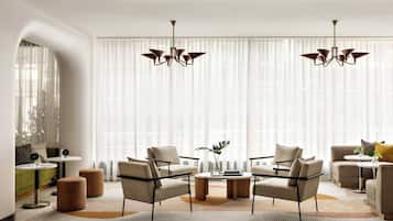 Een moderne woonkamer met een zithoek, salontafel en twee bijzettafels.