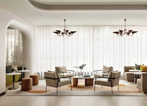 Uma sala de estar moderna com sofá, mesa de centro e duas mesas laterais.