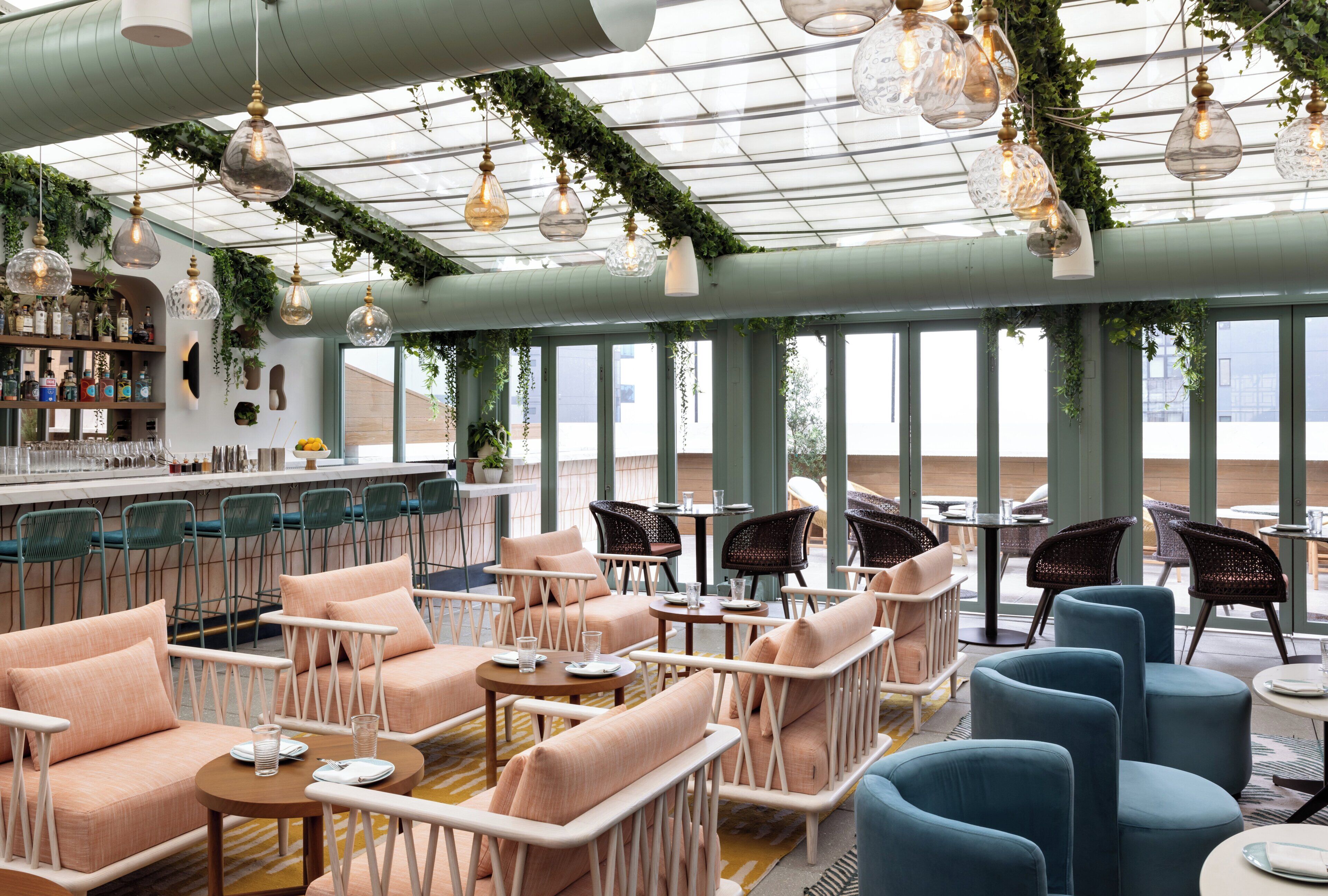 Un intérieur moderne avec un bar, des espaces de détente et de grandes fenêtres.
