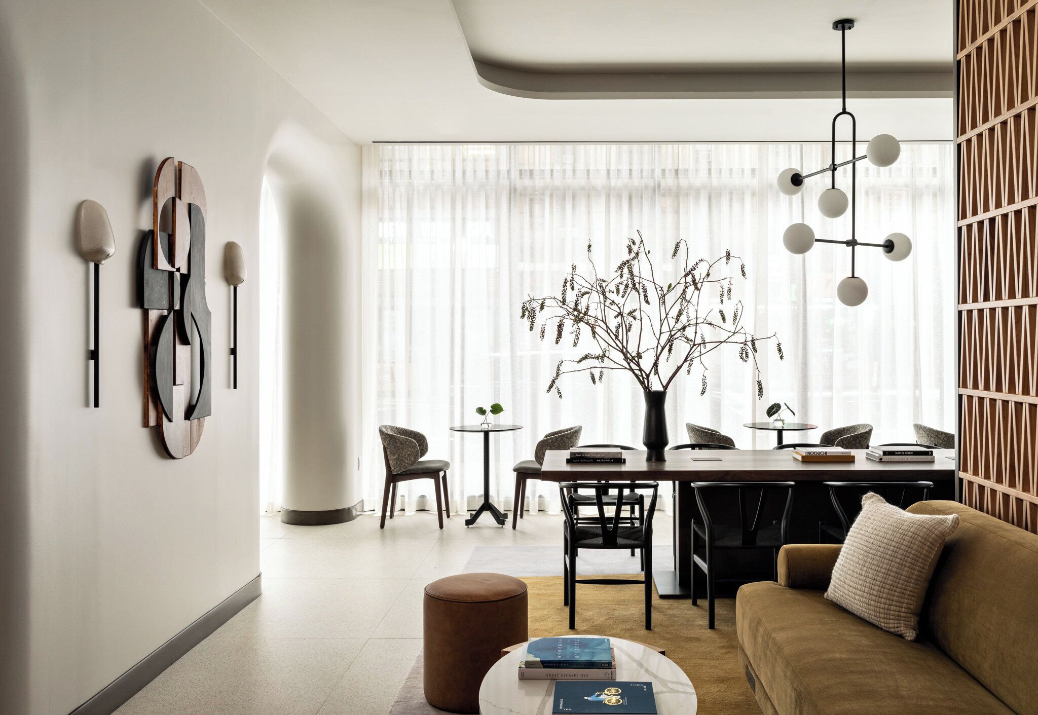 Una sala moderna con un sofá, una mesa de centro y un comedor con sillas y una mesa.