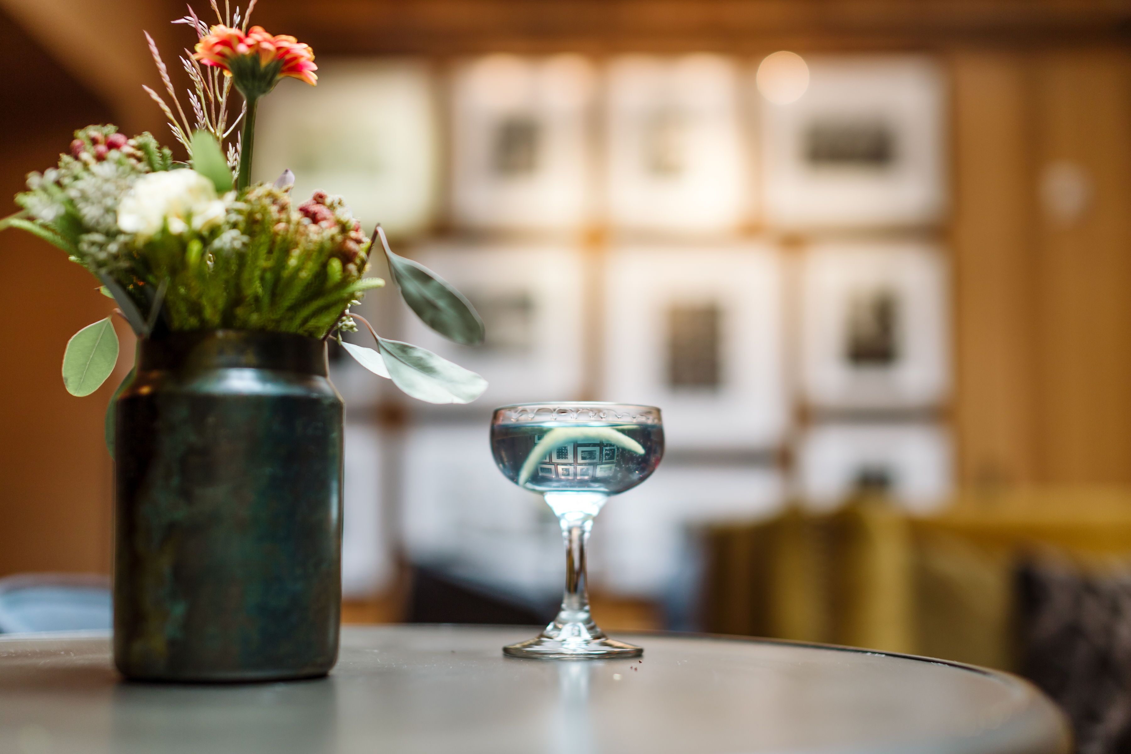 A vase with flowers and a glass on a table.