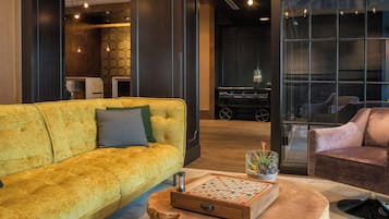 A modern living room with a yellow sofa, a wooden coffee table, and a chessboard.