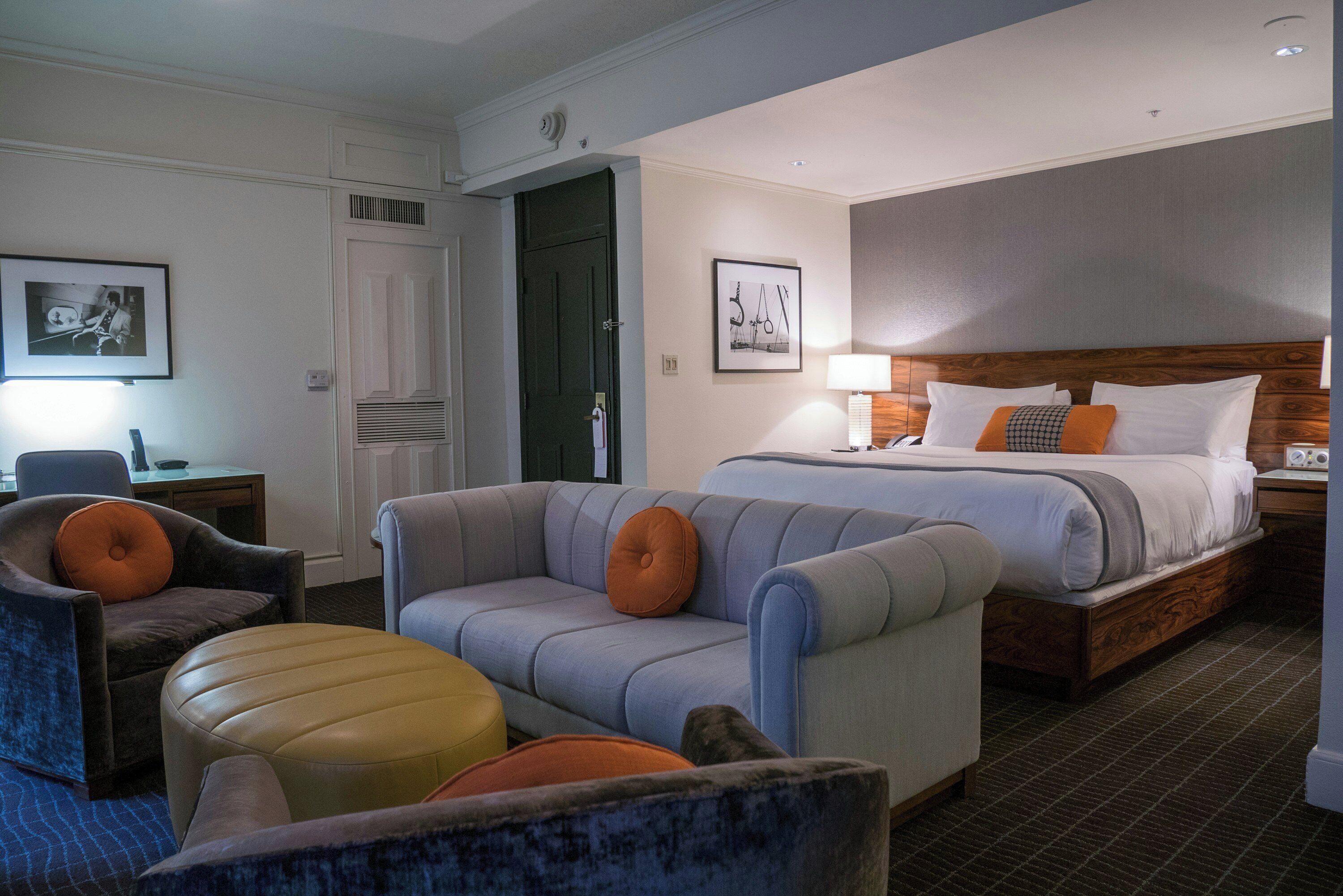 Ein Hotelzimmer mit Bett, Sofa, Sessel und Schreibtisch.