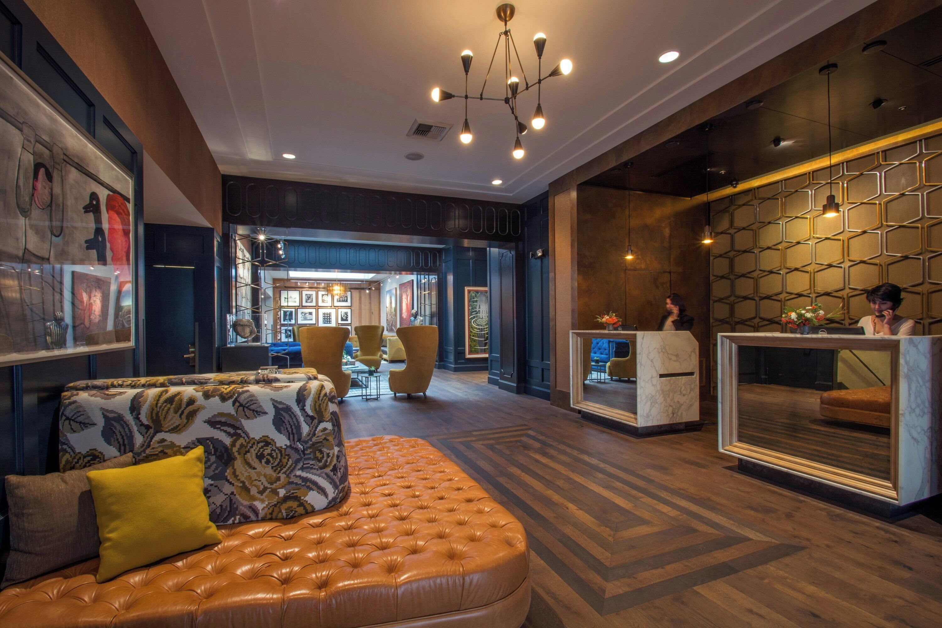 A lobby with a seating area, a reception desk, and a wall with hexagonal patterns.