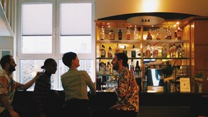 A bar area with shelves of liquor bottles and a sign that reads "BAR". - Grand Hostel Berlin Urban (Berlin)