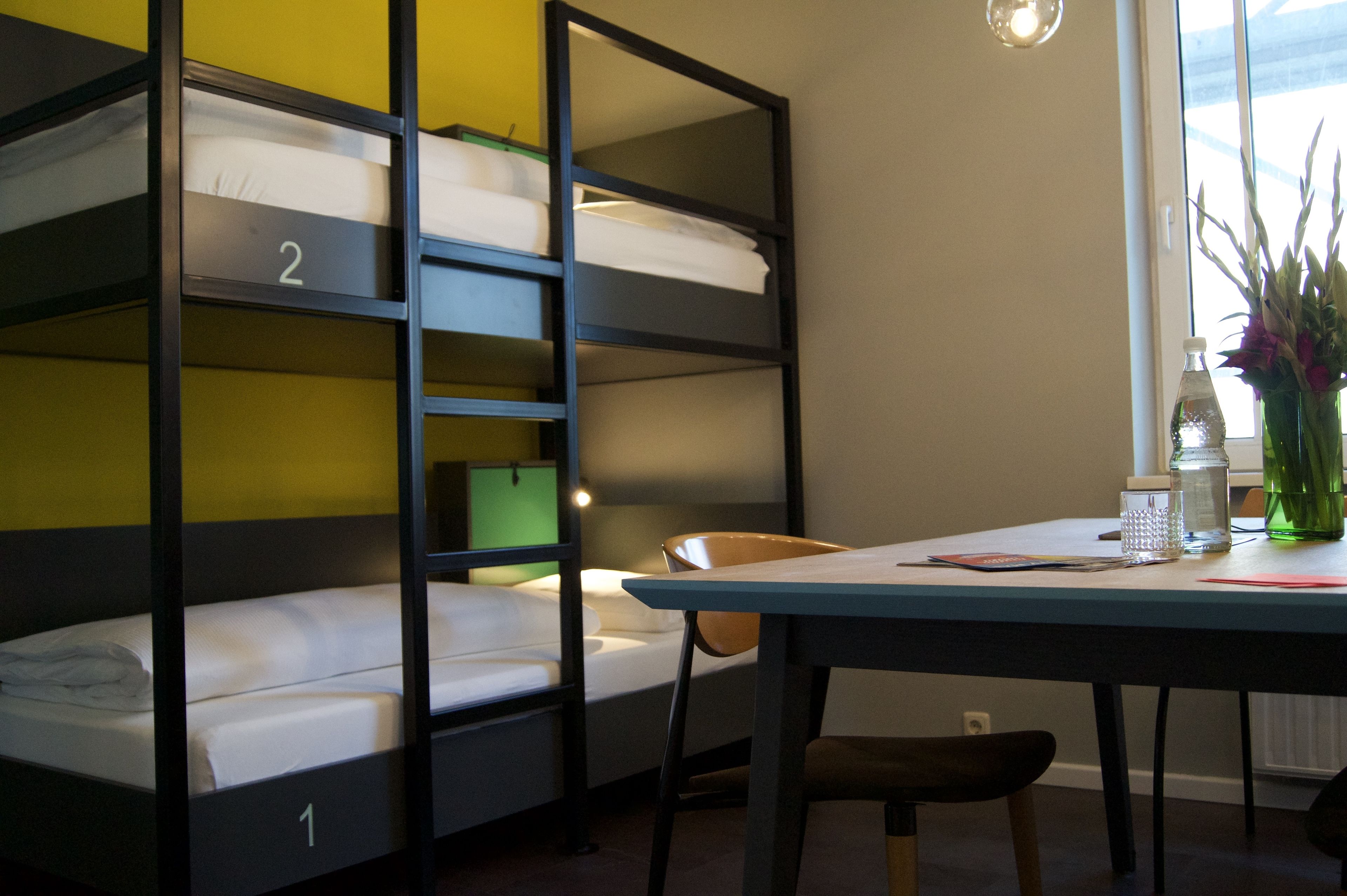 Tweepersoonsbedden, een tafel, stoelen en een raam met uitzicht.