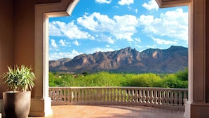 Un balcon avec vue sur les montagnes et la verdure.