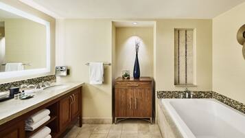 A modern bathroom with a large mirror, dual sinks, a wooden vanity, and a freestanding bathtub.