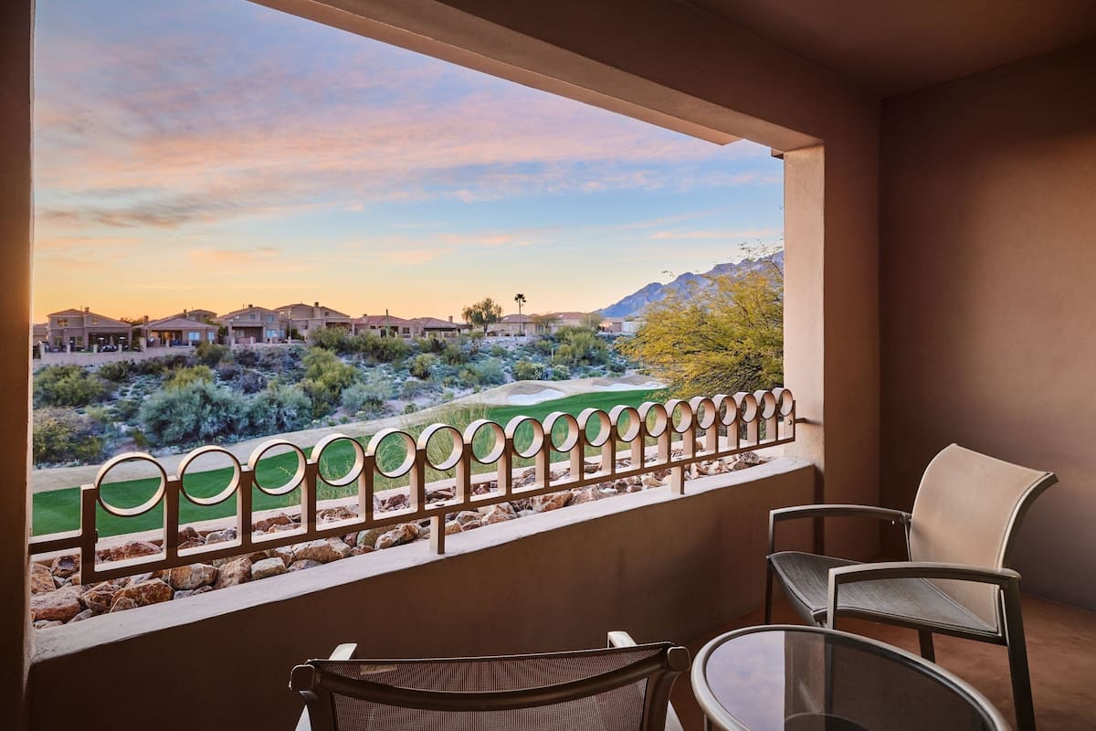 Un balcon offrant une vue sur un paysage désertique, avec des maisons et des montagnes en toile de fond.