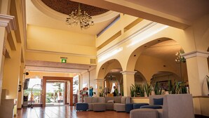 A spacious lobby with a high ceiling, a chandelier, and a seating area with sofas and ottomans. - Holiday Inn La Piedad by IHG (La Piedad)