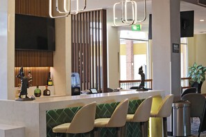 A reception area with a counter, seating, and a view of the street. - Holiday Inn La Piedad by IHG (La Piedad)