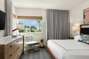 A hotel room with a bed, a desk, a chair, a TV, a window with a view, and a curtain.