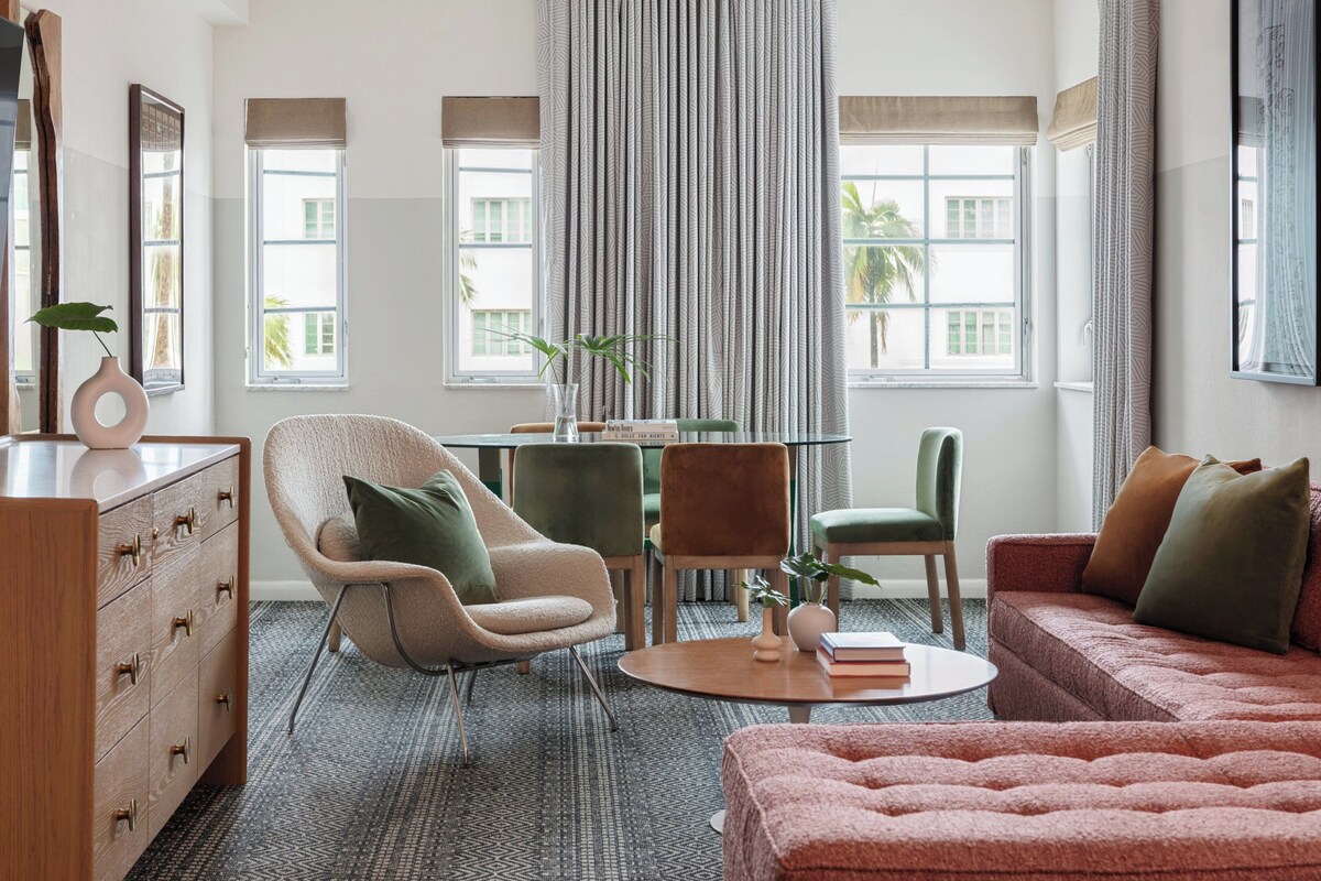 A modern living room with a sofa, chairs, a coffee table, and a dining table.