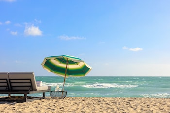 On the beach, sun loungers, beach yoga at Kimpton Surfcomber Hotel, an IHG Hotel