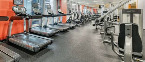 Et fitnesscenter med løbebånd, crosstrainere og styrkemaskiner.