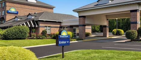 A Days Inn hotel with a clear entrance sign, brick exterior, and a covered parking area.