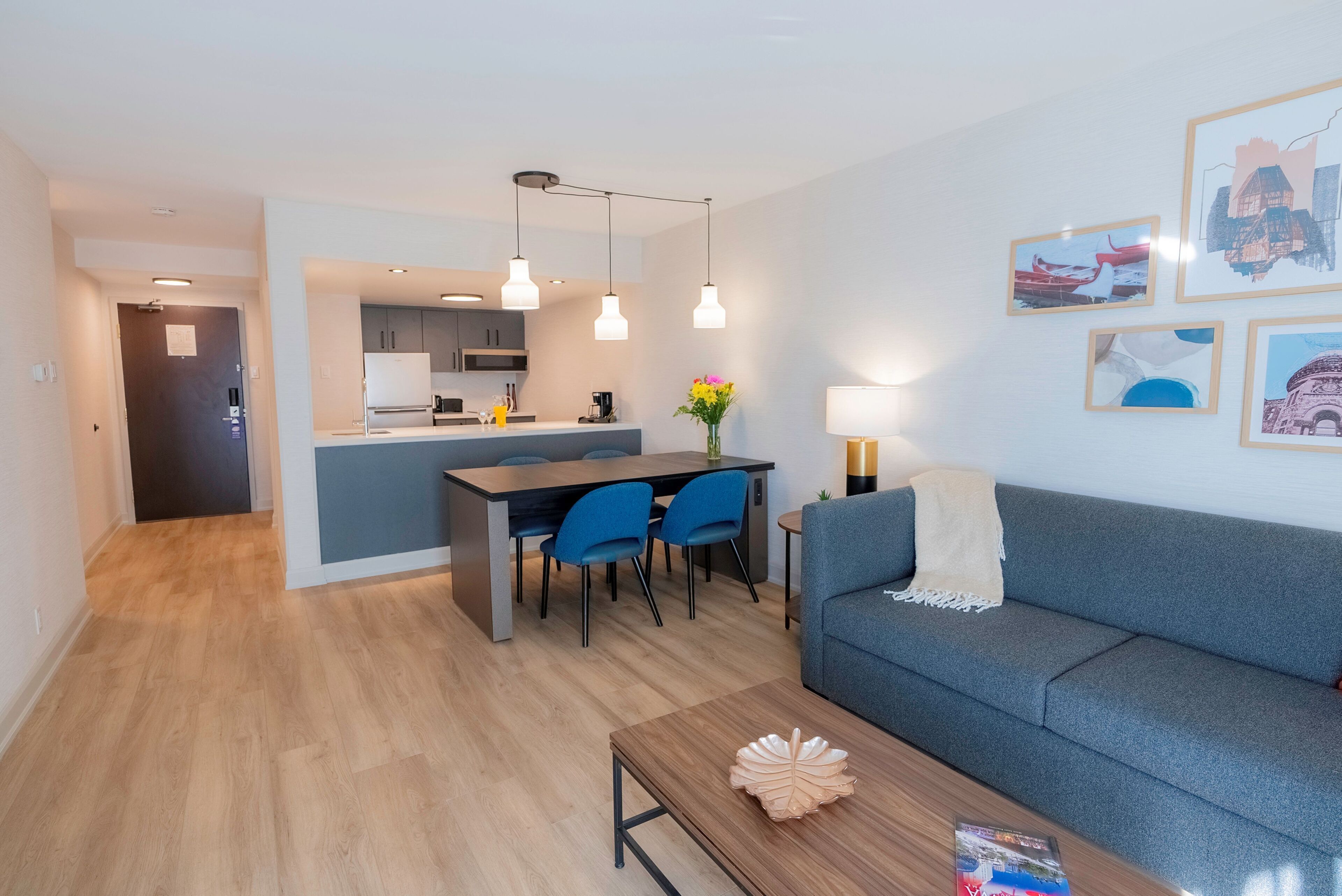 Un salon moderne comprenant un canapé, une table basse et un coin repas avec des chaises et une table.