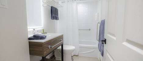 A modern bathroom with a toilet, sink, and shower.